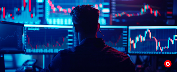 A man analyzing stock market graphs on multiple computer screens, ensuring compliance with forex trading regulations for safety.