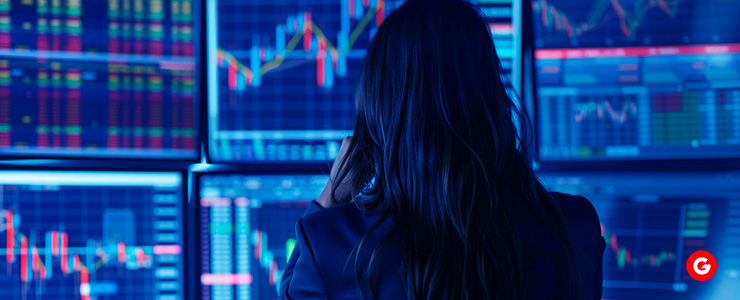 A woman analyzing stock market data on a computer screen, focusing on forex trading strategies.