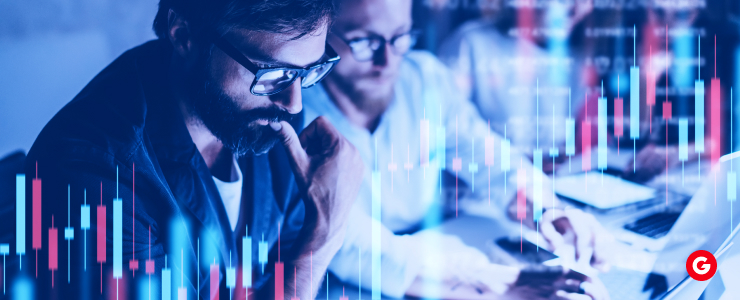 A group of individuals engaged in social forex trading, analyzing a chart on a laptop at a table.